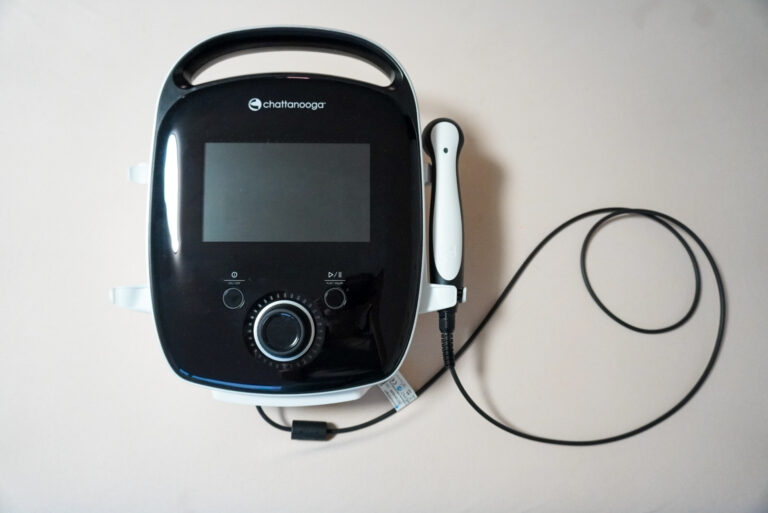 Therapiegerät mit Bildschirm und Handstück in der Praxis